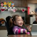baby with disability and mother laughing and watching video onli